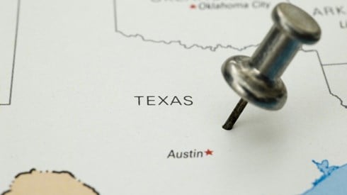 Outline map of the state of Texas with a thumbtack pushed into the state above Austin