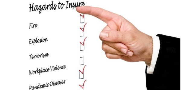 Businessman checking off coverages on an insurance hazards list with his finger