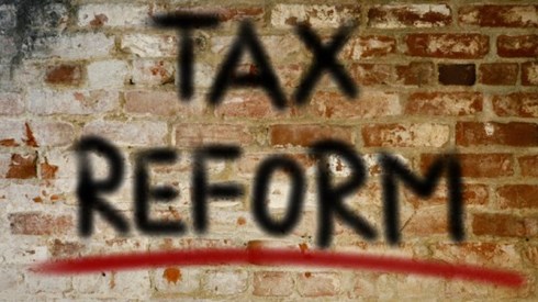 The words TAX REFORM are spray painted on a deteriorating brick wall