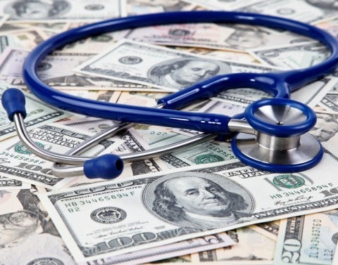 A stethoscope laying on a pile of money