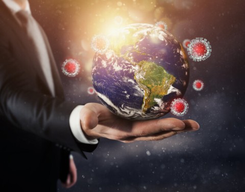 Man holding globe with COVID-19 virus around it