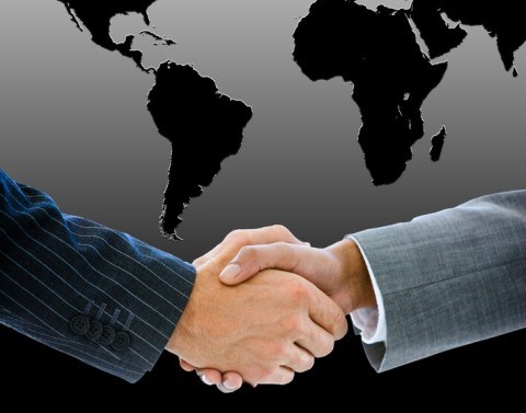 Businessman Shaking Hands in front of Outline of Southern Hemisphere