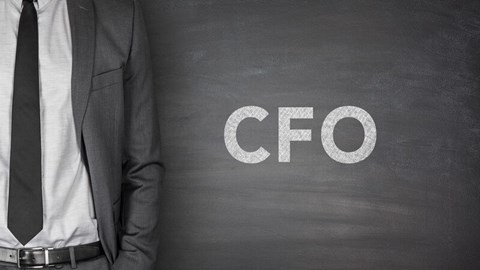 CFO written on chalkboard background with person in suit standing to the left