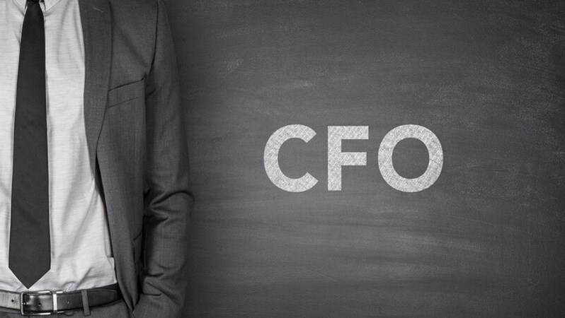 CFO written on chalkboard background with person in suit standing to the left