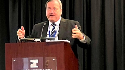 Mike Douglas, director of business development for Aon Captive and Insurance Management, speaking while standing behind a podium at the 2023 Texas Captive Insurance Association (TxCIA) annual meeting
