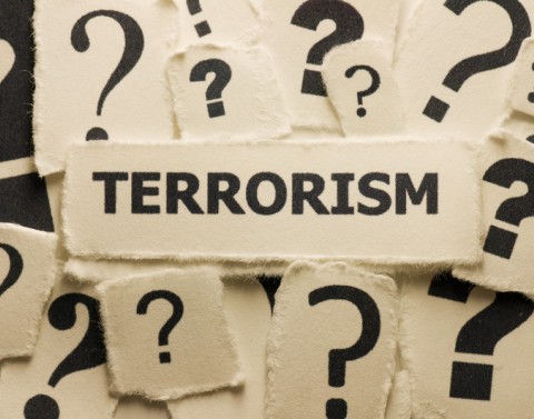 Terrorism and question marks typed on torn paper
