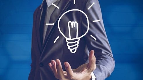 Businessman holding a drawn lightbulb with illumination lines